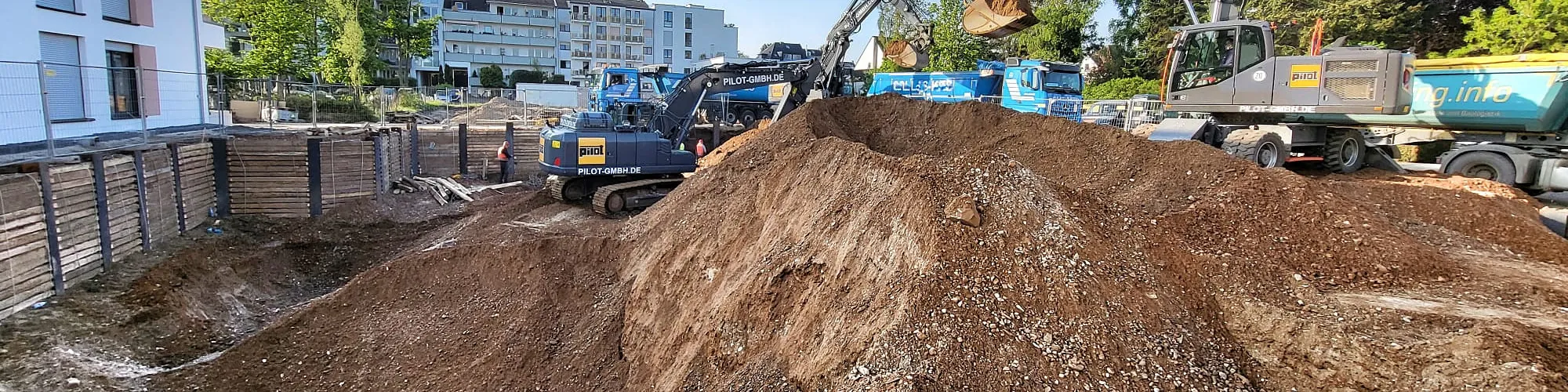 Baugrube mit Berliner Verbau und Bagger in Köln, Blick über die ganze Breite der Grube