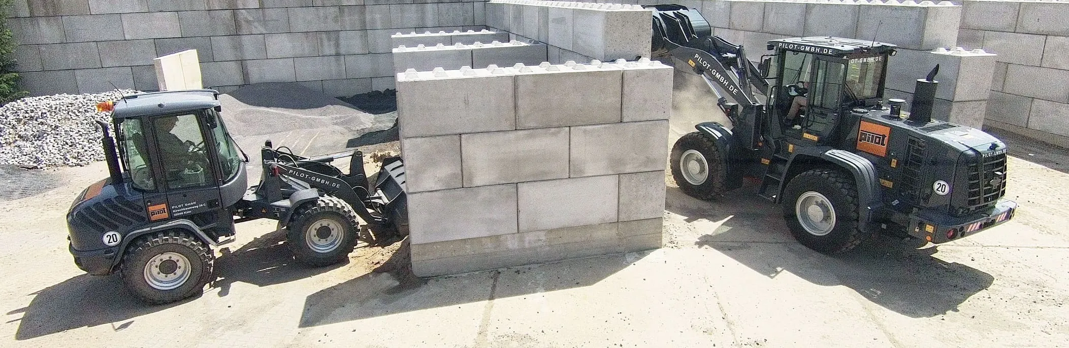 Zwei Radlader der PILOT GmbH beim Setzen von Betonfertigteilen